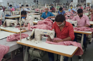 Indian garment factory workers operating sewing machines in Uttar Pradesh textile manufacturing workshop