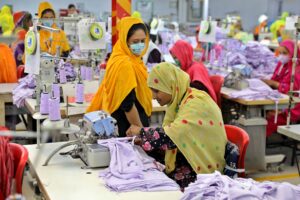 Bangladesh garment industry female workers operating sewing machines inside Dhaka apparel factory workshop